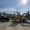 A construction yard with various John Deere excavators and a pickup truck, showcasing the machinery used for heavy-duty building tasks.