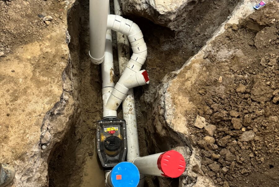 Close-up view of new PVC drain pipes in an open trench
