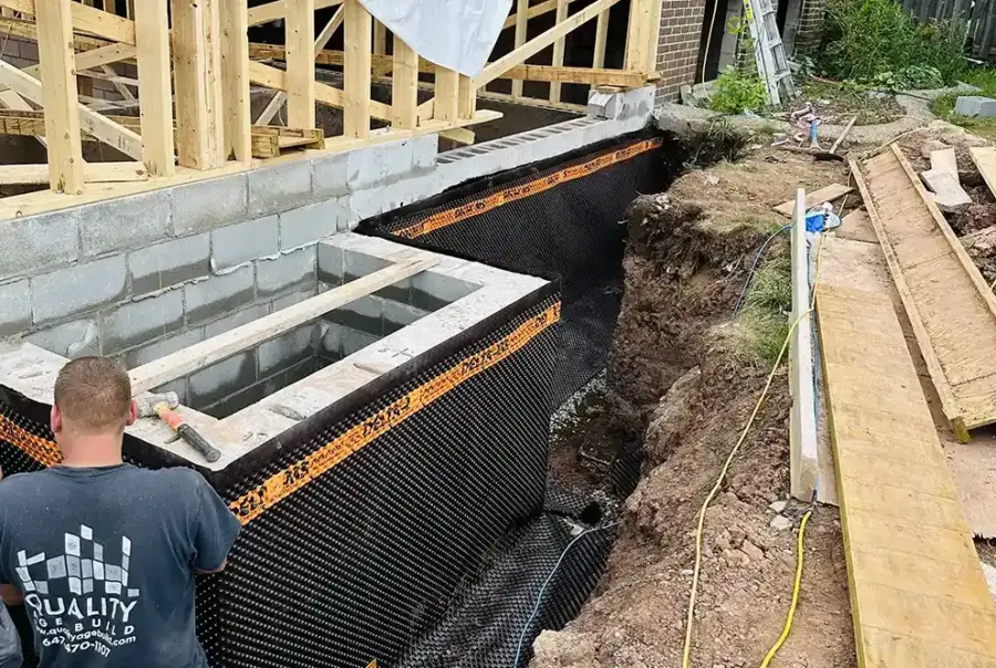 Construction worker installing waterproof membrane foundation for a Laneway Suite project