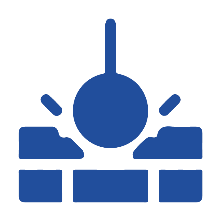 Blue wrecking ball demolishing a wall representing demolition services.