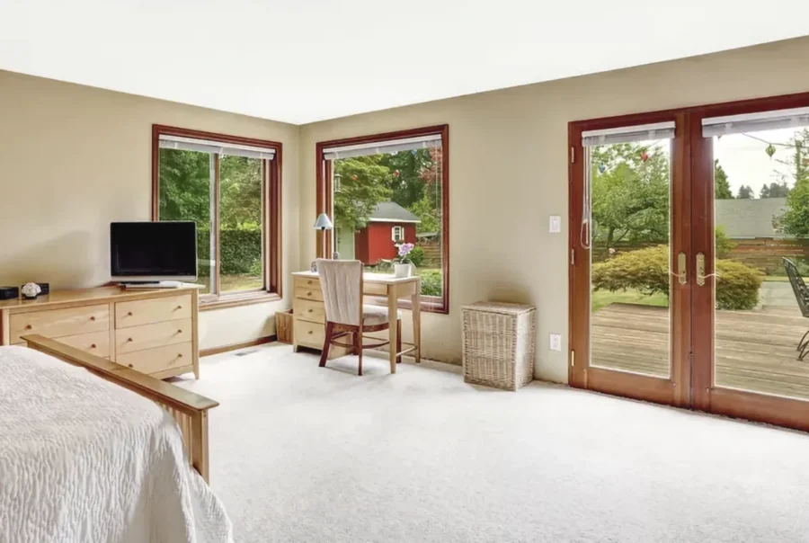 Bright walkout basement bedroom with glass doors and garden view