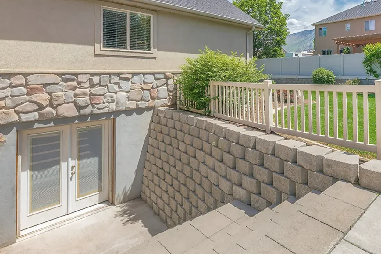 Walkout basement entrance with stone wall and retaining wall