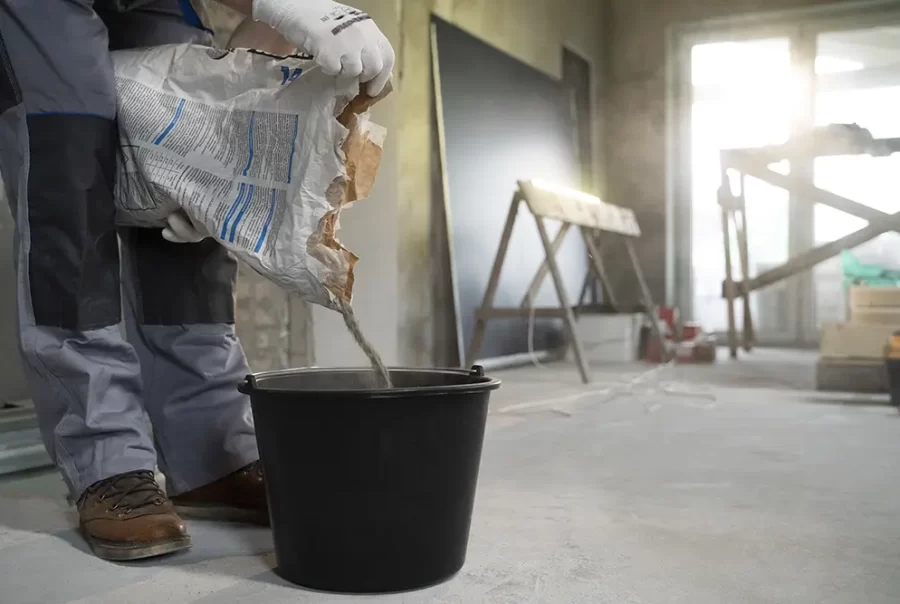 Cement powder being poured into a bucket for mixing