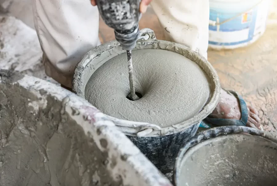 Cement mixture being blended with a drill mixer in a bucket